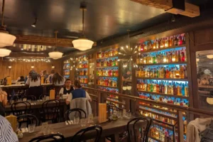 Trendy Paris dining room with backlit liquor wall