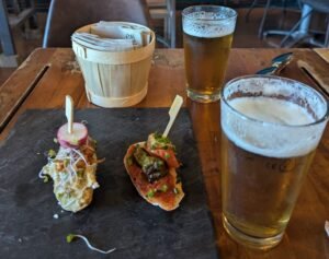 Tapas-style appetizers served with beer in a Paris bistro